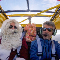 Zach transportant le Père Noël et ses cadeaux dans son ulm jaune
