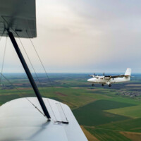 Vol en biplan Stampe à côté du Twin Otter
